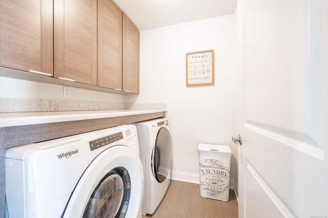 washroom featuring cabinets and washing machine and clothes dryer