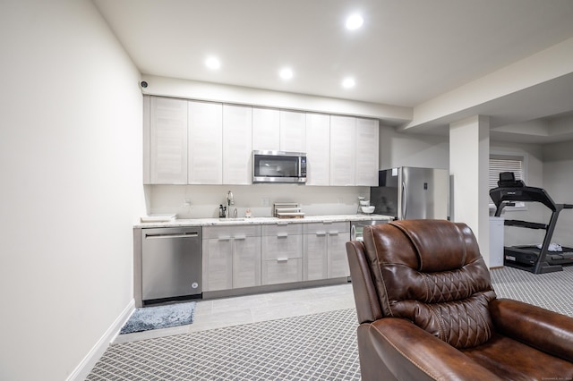 kitchen featuring recessed lighting, a sink, stainless steel appliances, modern cabinets, and open floor plan