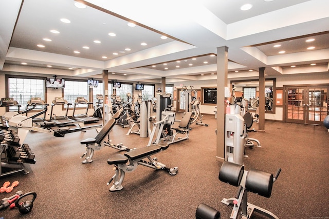 gym with a tray ceiling, recessed lighting, and french doors