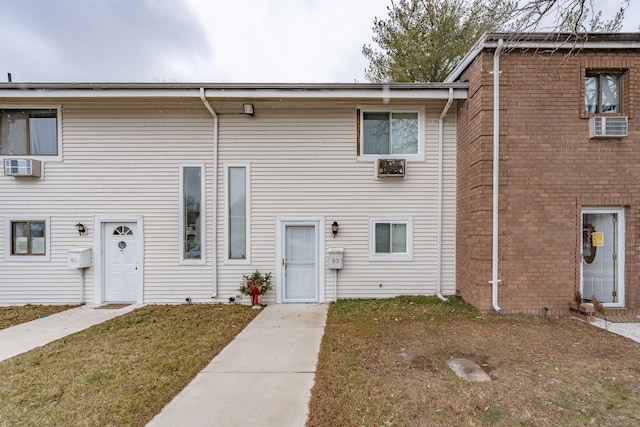 multi unit property featuring a front yard and an AC wall unit