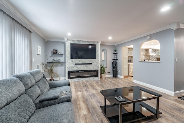 living room featuring crown molding, a fireplace, and wood-type flooring