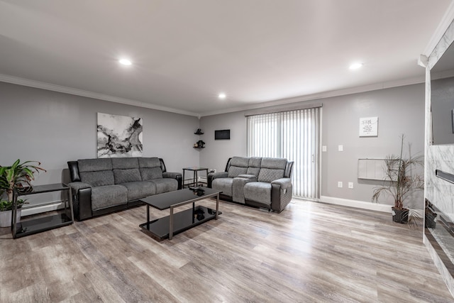 living room featuring a baseboard heating unit, light hardwood / wood-style flooring, and ornamental molding