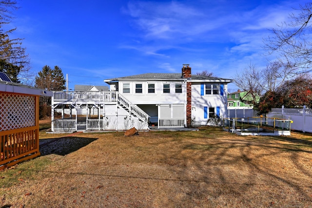 back of property featuring a wooden deck and a yard