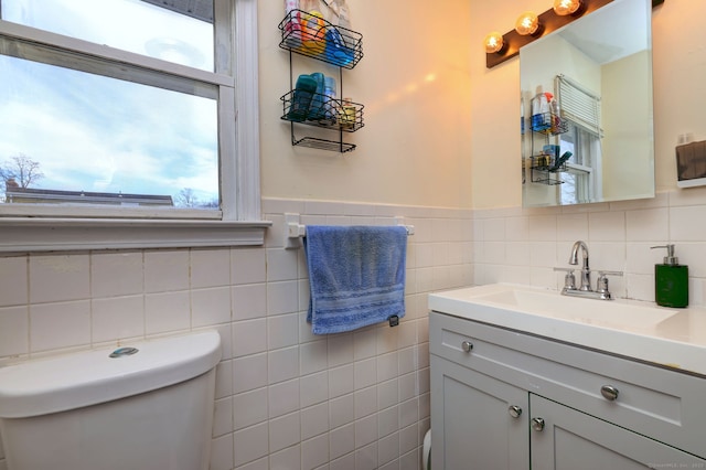 bathroom featuring vanity, tile walls, and toilet