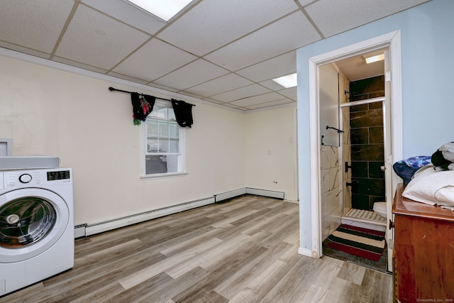 washroom with baseboard heating, light hardwood / wood-style floors, and washer / dryer