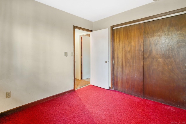 unfurnished bedroom featuring a closet and light colored carpet