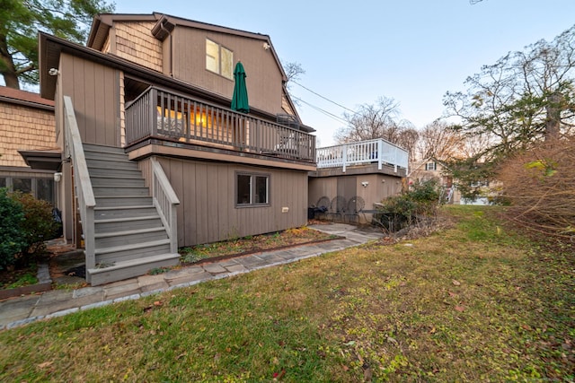 rear view of house with a lawn and a wooden deck