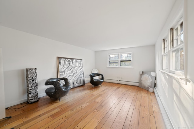 sitting room with a baseboard radiator and hardwood / wood-style flooring