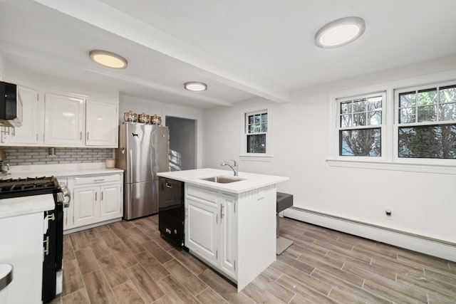 kitchen featuring white cabinets, a center island with sink, and sink