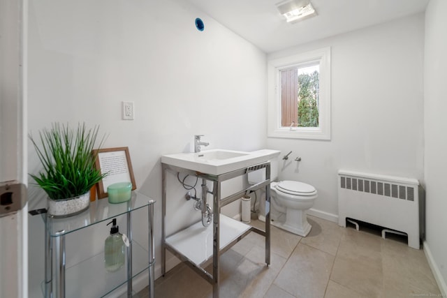 bathroom featuring tile patterned flooring, toilet, radiator, and sink