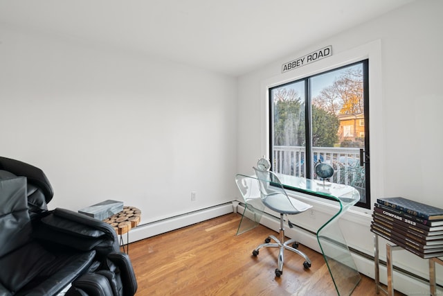 home office featuring hardwood / wood-style floors and a baseboard heating unit