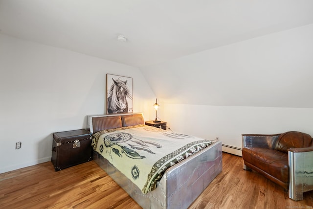 bedroom with hardwood / wood-style flooring, baseboard heating, and lofted ceiling