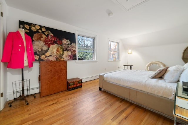 bedroom featuring a baseboard radiator, vaulted ceiling, and wood-type flooring