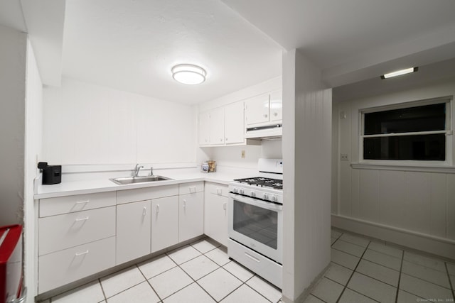 kitchen with white cabinets, white range with gas stovetop, sink, and light tile patterned floors