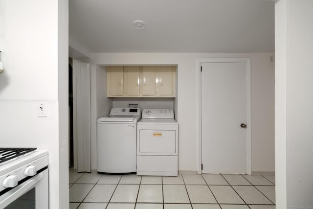 laundry room with separate washer and dryer, light tile patterned flooring, and cabinets