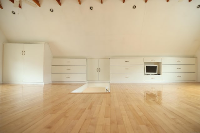 additional living space with ceiling fan, lofted ceiling with beams, and light wood-type flooring