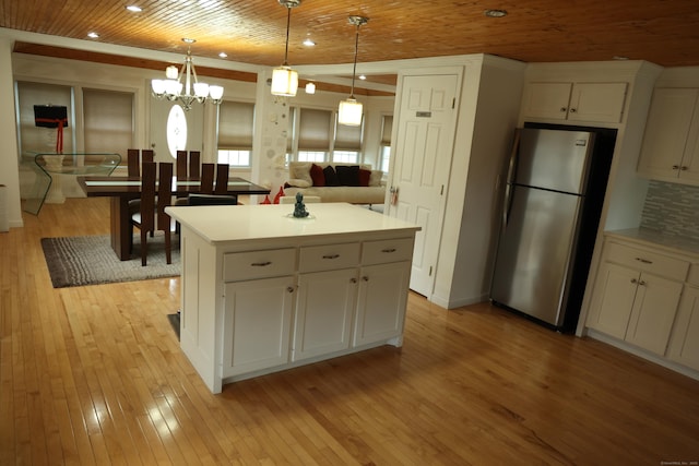 kitchen with a center island, white cabinets, stainless steel fridge, decorative light fixtures, and wood ceiling