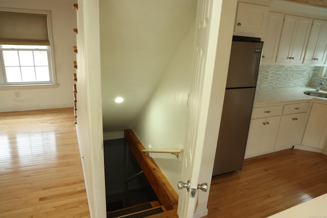 staircase with hardwood / wood-style floors and sink