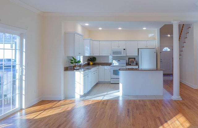 kitchen with white appliances, a center island, and white cabinets