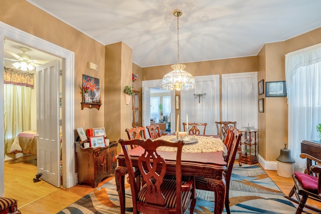 dining area featuring ceiling fan with notable chandelier and light hardwood / wood-style flooring