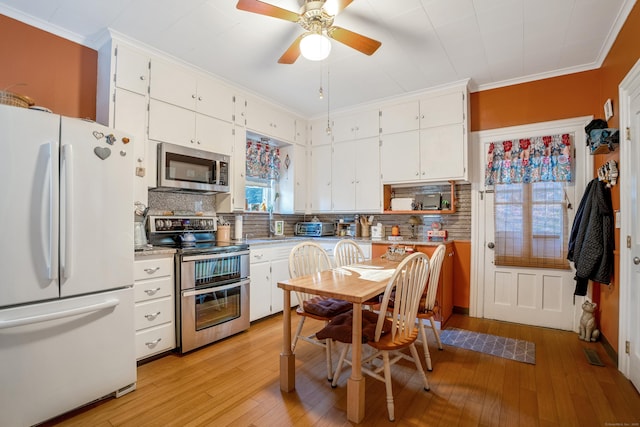 kitchen with white cabinets, backsplash, and appliances with stainless steel finishes