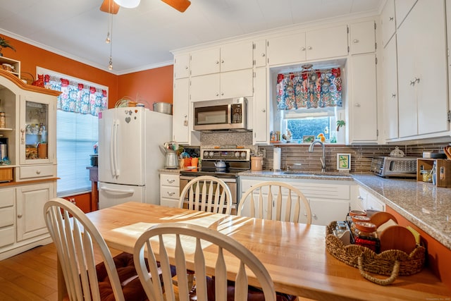 kitchen featuring white cabinets, decorative backsplash, light stone countertops, and stainless steel appliances