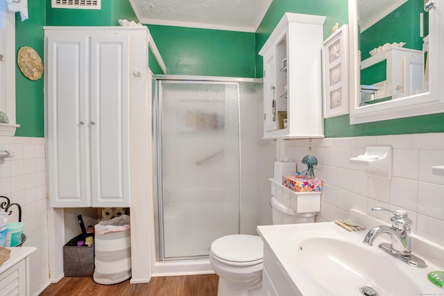 bathroom featuring sink, a textured ceiling, hardwood / wood-style flooring, a shower with door, and ornamental molding