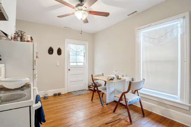 dining space with ceiling fan and light hardwood / wood-style flooring