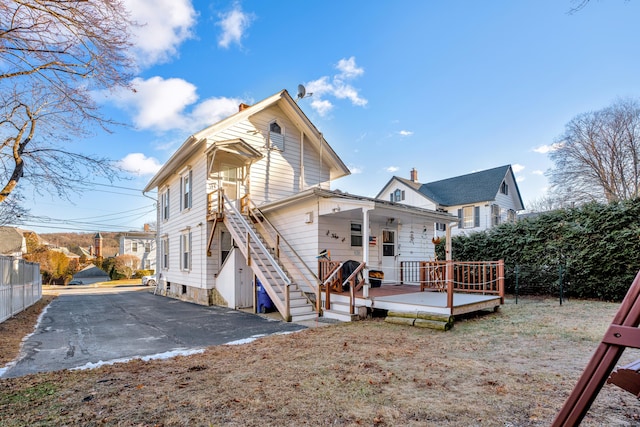 rear view of property with a porch and a deck