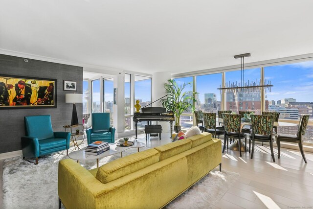 living room with floor to ceiling windows, a notable chandelier, and light wood-type flooring