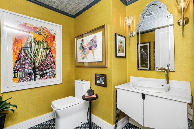 bathroom with toilet, vanity, ornamental molding, and tile patterned flooring