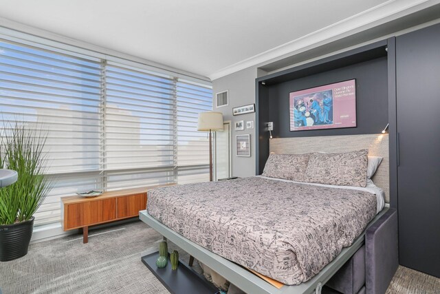 bedroom with ornamental molding and carpet