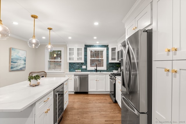 kitchen featuring decorative backsplash, appliances with stainless steel finishes, beverage cooler, sink, and white cabinets