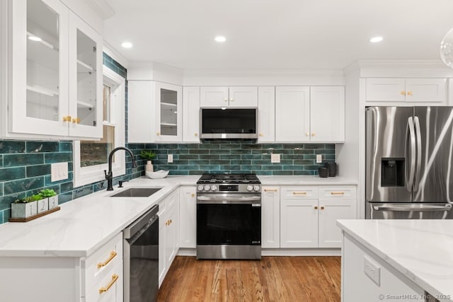 kitchen featuring white cabinetry, sink, stainless steel appliances, light stone counters, and light hardwood / wood-style floors