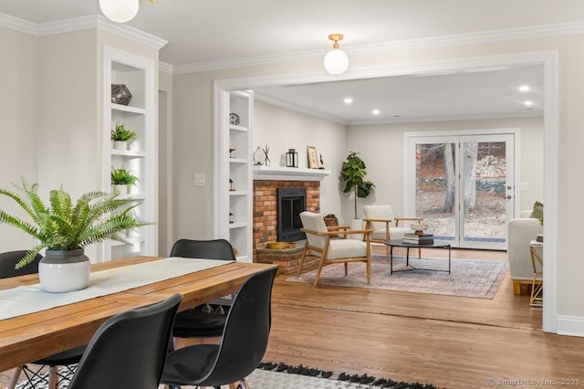 office space featuring ornamental molding, built in features, wood-type flooring, and a brick fireplace