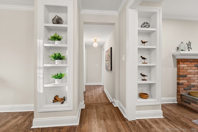 hall featuring built in shelves, dark hardwood / wood-style flooring, and ornamental molding