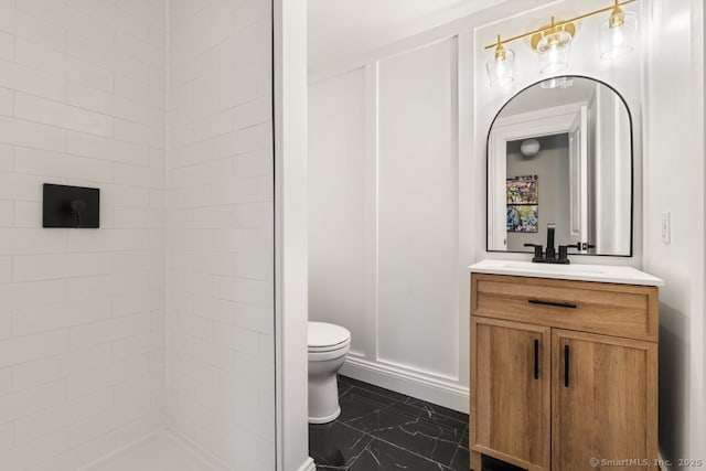 bathroom with vanity, toilet, and a shower