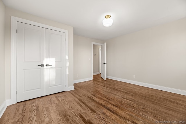 unfurnished bedroom featuring hardwood / wood-style flooring and a closet