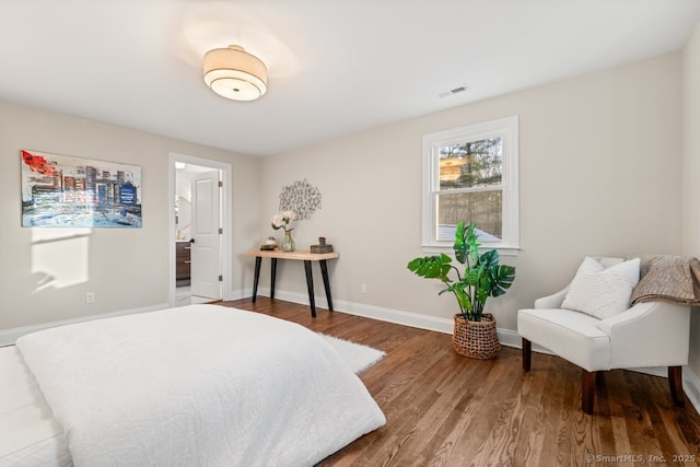 bedroom with ensuite bathroom and hardwood / wood-style floors