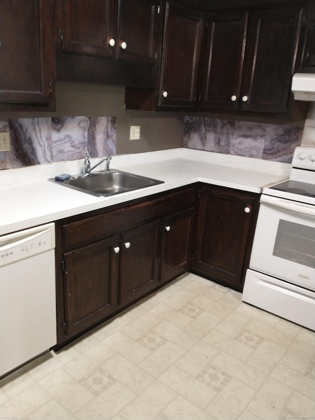 kitchen featuring dark brown cabinetry, white appliances, sink, and range hood