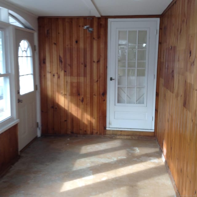 doorway to outside featuring wooden walls