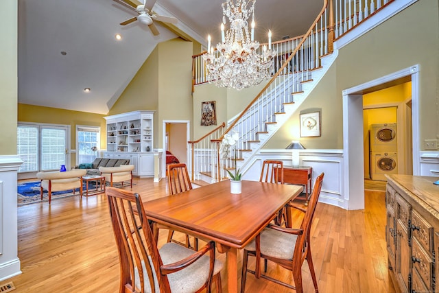 120 Imperial Ct Unit 120, Trumbull, CT 06611 - dining space featuring ceiling fan with notable chandelier, stacked washer and dryer, high vaulted ceiling, and light hardwood / wood-style flooring