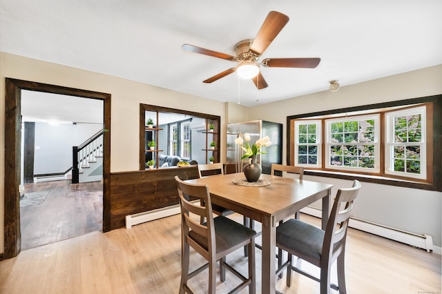 dining room featuring a baseboard radiator, ceiling fan, and light hardwood / wood-style floors