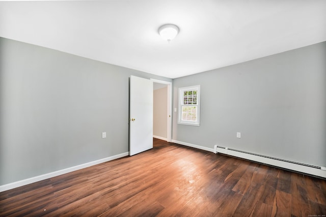 empty room featuring a baseboard radiator and dark hardwood / wood-style floors