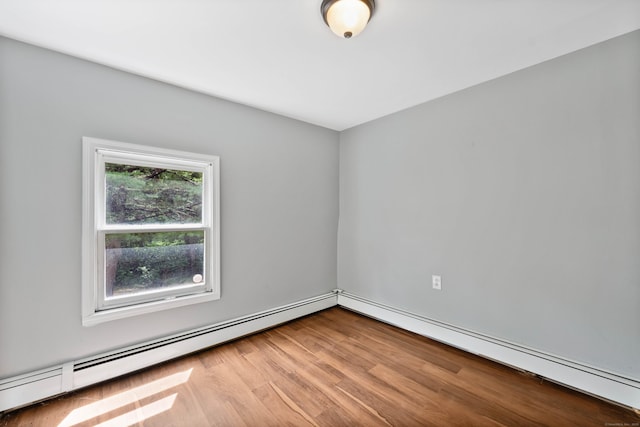 empty room featuring light hardwood / wood-style floors and a baseboard heating unit