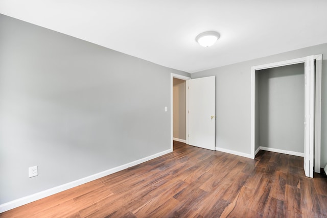 unfurnished bedroom featuring dark hardwood / wood-style floors and a closet