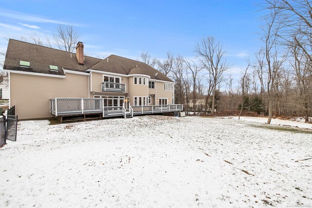 snow covered house with a deck