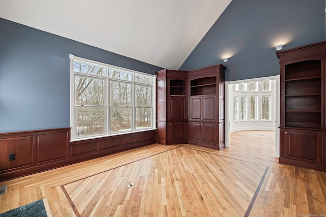 interior space featuring light wood-type flooring and high vaulted ceiling