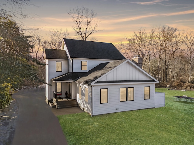 back house at dusk featuring a yard