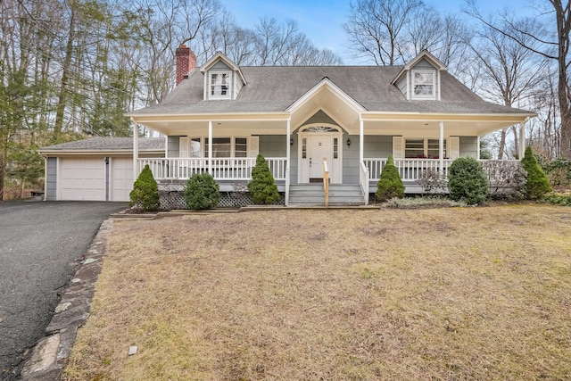 cape cod-style house with covered porch, a front lawn, and a garage